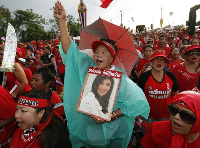 Een demonstrante houdt een foto van premier Yingluck Shinawatra vast.
