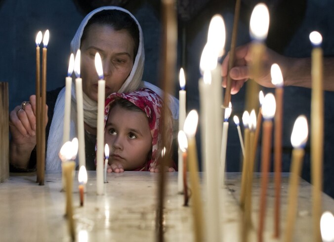 Orthodoxe gelovigen steken kaarsen aan in een kerk in Jeruzalem.