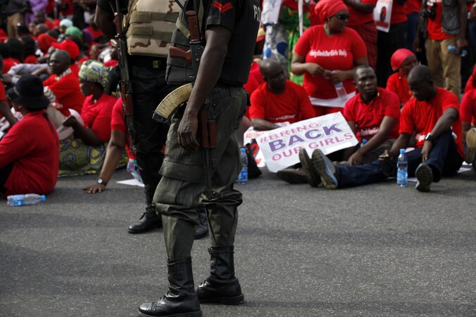 Gewapende Nigeriaanse agenten bij demonstranten die eisen dat de regering de zoektocht naar de meisjes opdrijft.