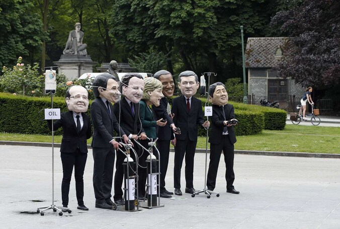 Oxfam-activisten demonstreren in Brussel met de maskers van de G7-leden op
