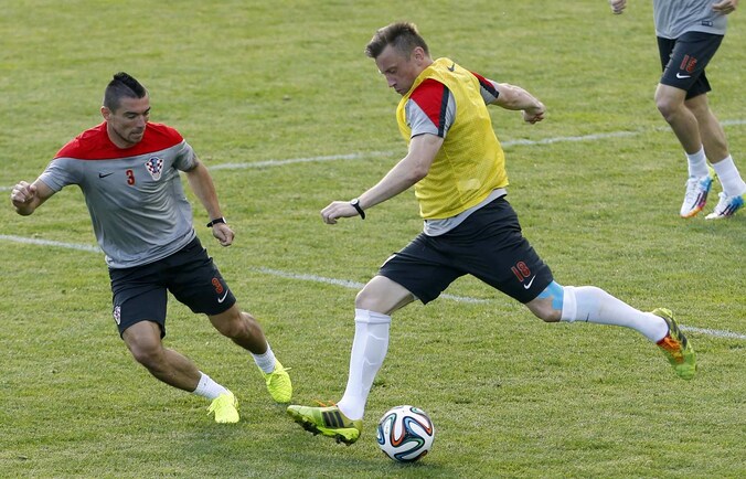 Pranjic (L) probeert hier een schot van Olic af te blokken.