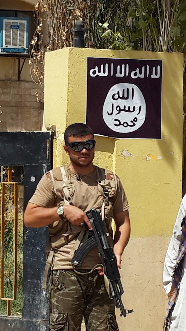 Een IS-strijder in het veroverde christelijke dorp Bartella, in het noorden van Irak.