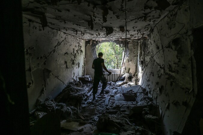 Een man bezoekt zijn verwoest huis in Donetsk.