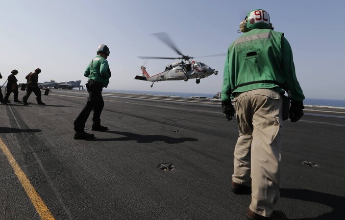 Een Amerikaanse gevechtshelikopter keert terug naar het vliegdekschip USS George H.W. Bush na een missie in Irak.