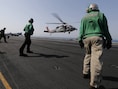 Een Amerikaanse gevechtshelikopter keert terug naar het vliegdekschip USS George H.W. Bush na een missie in Irak.