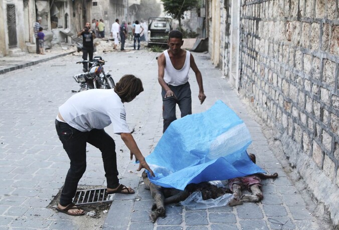 Mannen dekken de lichamen af van slachtoffers in de Syrische stad Aleppo op 21 juli