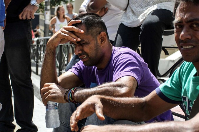 Een migrant huilt tijdens een protestactie voor de rechtbank in Patras.