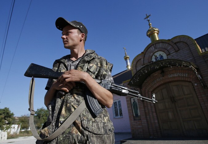 Een pro-Russische separatist houdt de wacht nabij het Oekraïense Ilovaysk. Een staakt-het-vuren lijkt voorlopig stand te houden.