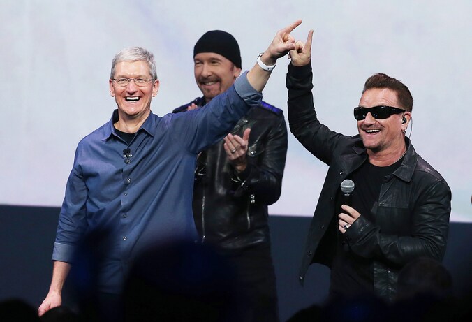 Apple-CEO Tim Cook en U2-zanger Bono zijn maar wat blij met de muzikale release tijdens het Apple-evenement.