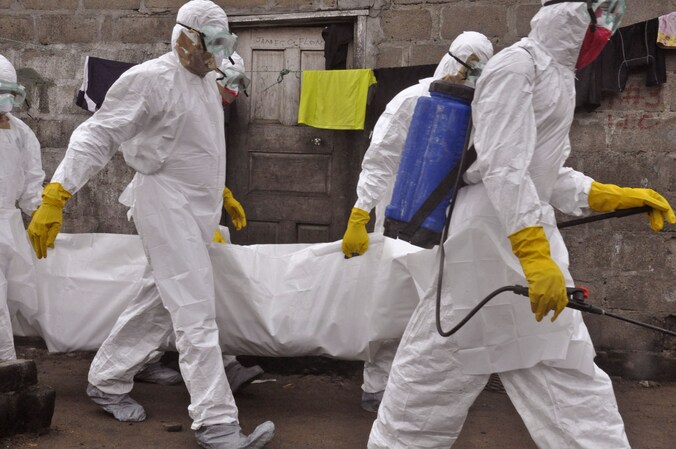 Gezondheidswerkers dragen het lichaam van een vrouw die aan ebola overleed weg in de Liberiaanse hoofdstad Monrovia.