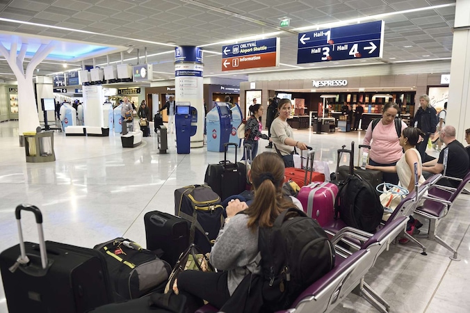 Reizigers wachten op hun vlucht in de luchthaven van Orly.
