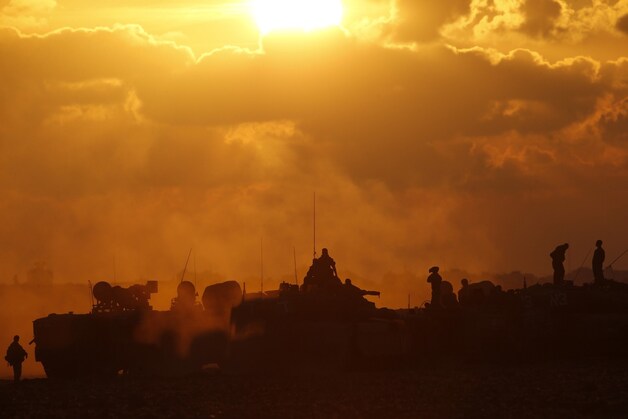 Israëlische militairen staan op tanks.