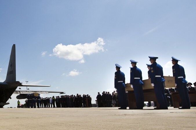 De lichamen worden aan boord gedragen na een korte ceremonie.