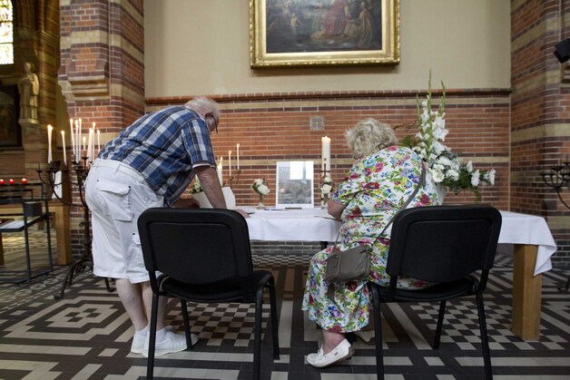 Kerkgangers tekenen het condoleanceregister in een kerk in Hilversum.