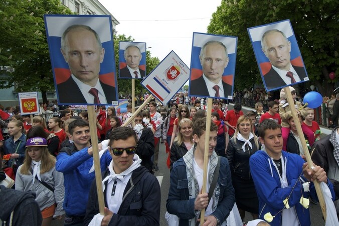 Demonstranten lopen met foto's van de Russische president Vladimir Poetin door Simferopol, de hoofdstad van de Krim.