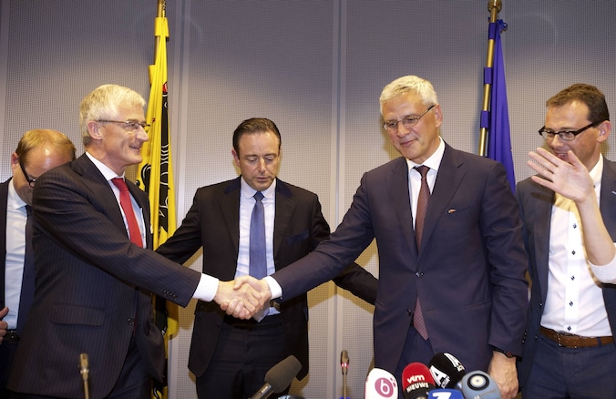 Geert Bourgeois en Kris Peeters schudden elkaar de hand onder het oog van Bart De Wever.
