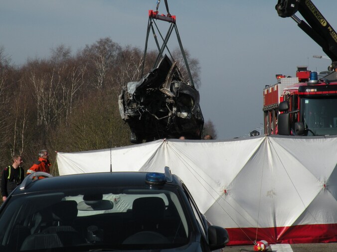 Het uitgebrande autowrak wordt van de E314 gelift.