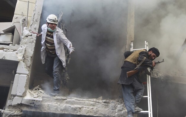 Reddingswerkers zijn op zoek naar overlevenden na een aanslag met vatenbommen in Aleppo.
