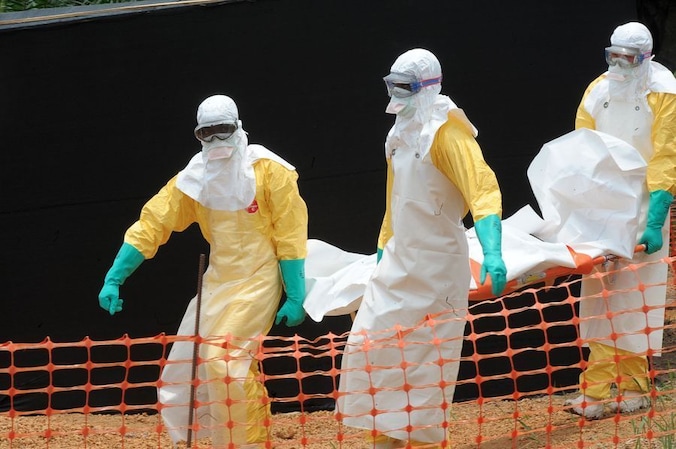Medewerkers van Artsen zonder Grenzen vervoeren het lichaam van een persoon die is bezweken aan de gevolgen van het ebolavirus, Guinea.
