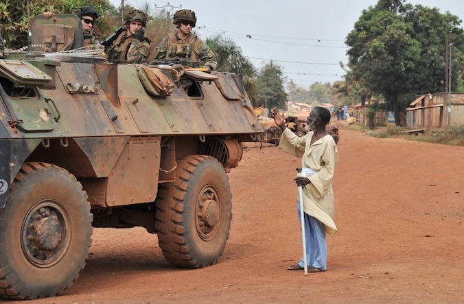 Een inwoner van Bangui benadert een Franse militaire patrouille.