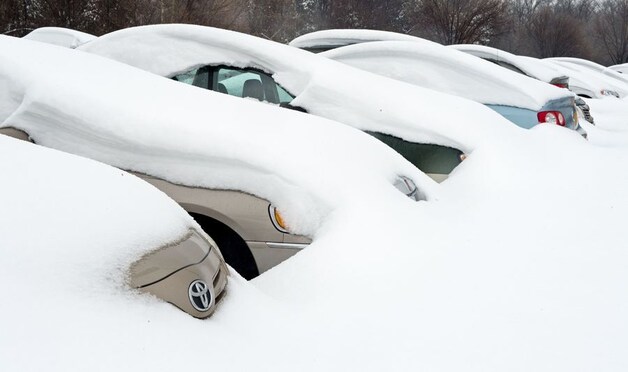 Auto's bedolven onder sneeuw bij het Dulles International Airport in de staat Virginia.