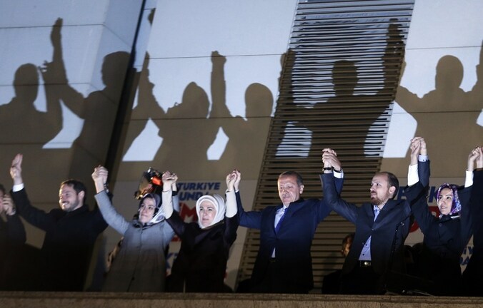 Premier Erdogan en familieleden op het balkon van het partijkantoor in Ankara, zondagavond. Een menigte juicht hen toe.