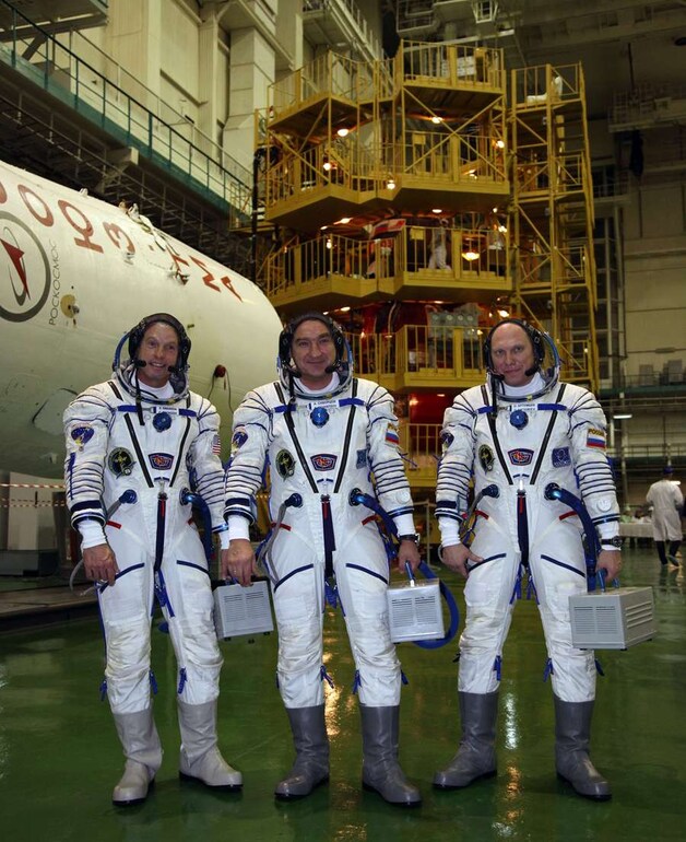 De Amerikaanse ruimtevaarder Steven Swanson (L) samen met zijn Russische collega's Alexander Skvortsov (midden) en Oleg Artemyev vlak voor het vertek naar het ruimtestation ISS.