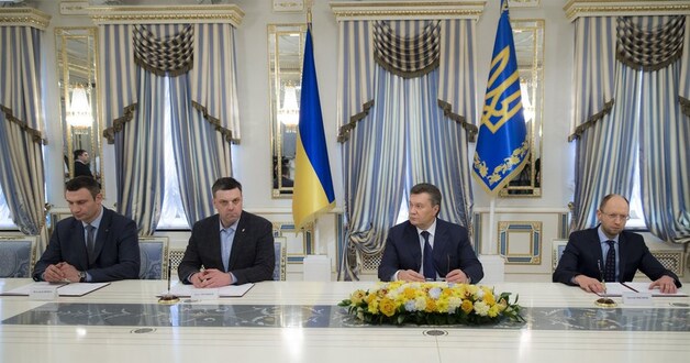 De drie oppositieleiders en president Janoekovitsj bij de ondertekening van het akkoord.