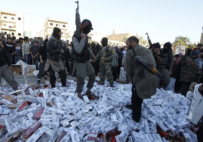 ISIL-aanhangers vernietigen in beslag genomen sigarettenpakken in de Syrische stad Raqqa.
