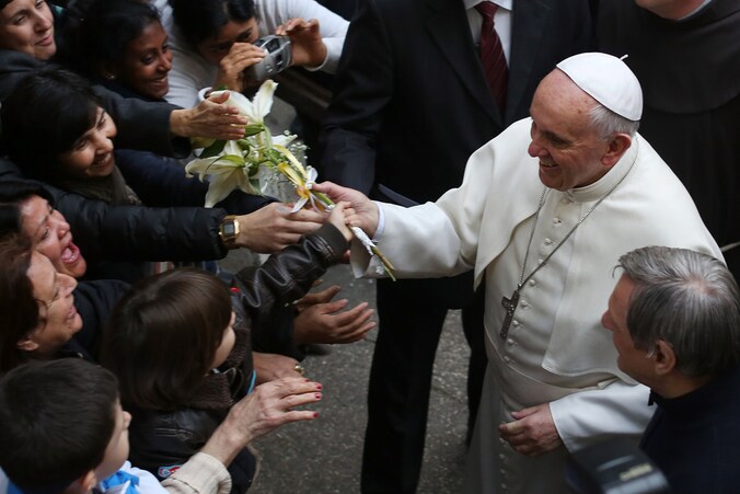 Paus Franciscus begroet gelovigen bij aankomst aan de San Gregorio VII-kerk in Rome.