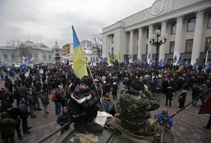 Betogers staan voor het parlementsgebouw in Kiev terwijl het parlement zich binnen vergadert over de nieuwe coalitieregering.