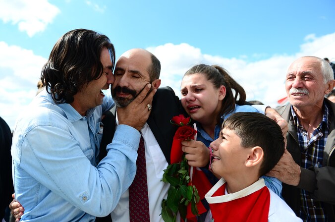 Familieleden begroeten de bevrijde Turkse gegijzelden op het vliegveld van Ankara.