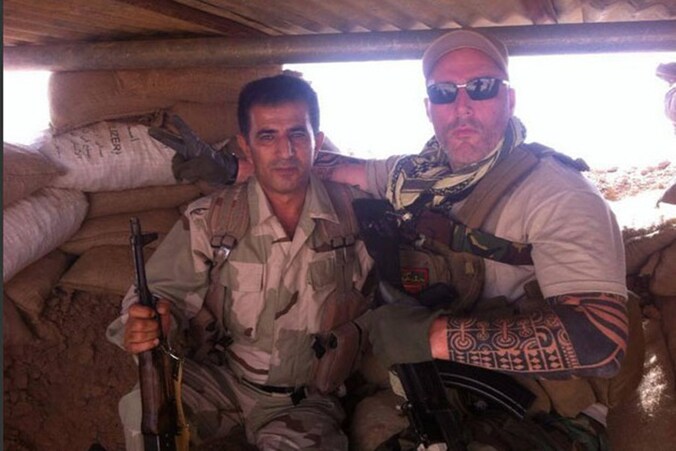 Nederlander Ron (rechts), lid van motorbende No Surrender, poseert naast een Koerdische strijdmakker in een bunker in de buurt van Mosoel.