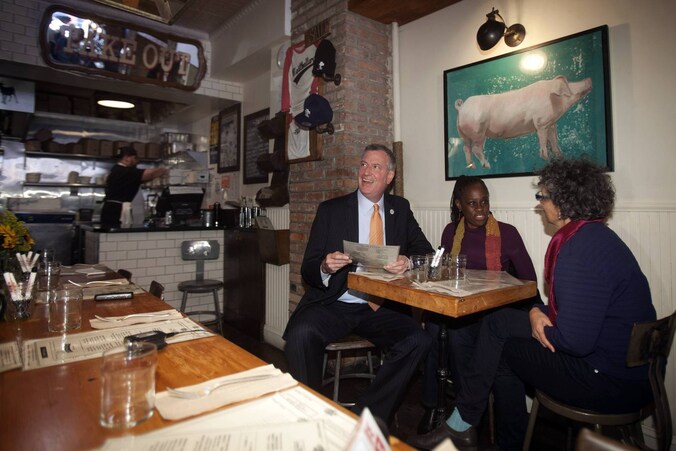 Burgemeester Bill de Blasio, zijn vrouw Chirlaine McCray en de gezondheidscommissaris van New York Mary Travis Bassett vanmiddag in The Meatball Shop.