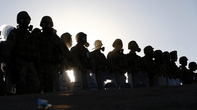 Turkse veiligheidstroepen met gasmaskers op bewaken de Turks-Syrische grens.