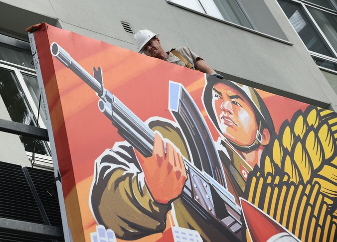Een arbeider verwijdert een poster van 'The Interview' in Hollywood.