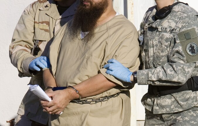 Een gevangene op Guantánamo Bay wordt weggeleid.