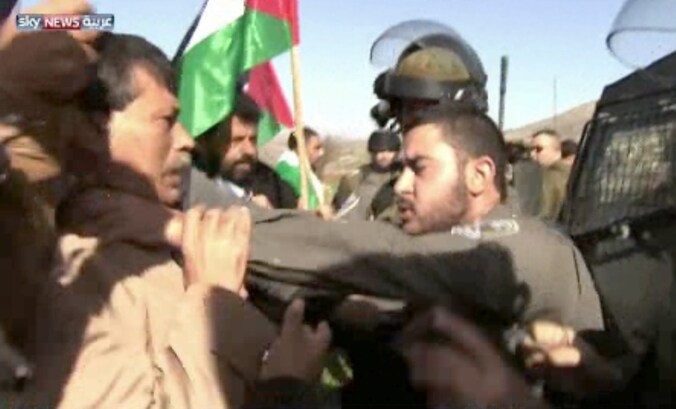 Een Israëlische officier (r) greep de Palestijnse minister (l) gisteren bij de keel.