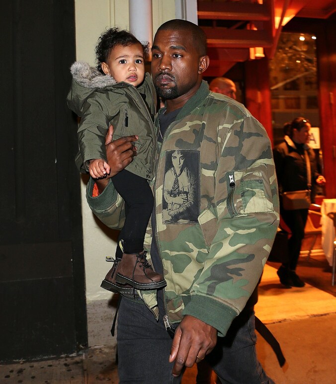 Kanye West met dochtertje North op de arm.