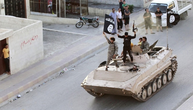 Leden van IS rijden door de straten van Raqqa.