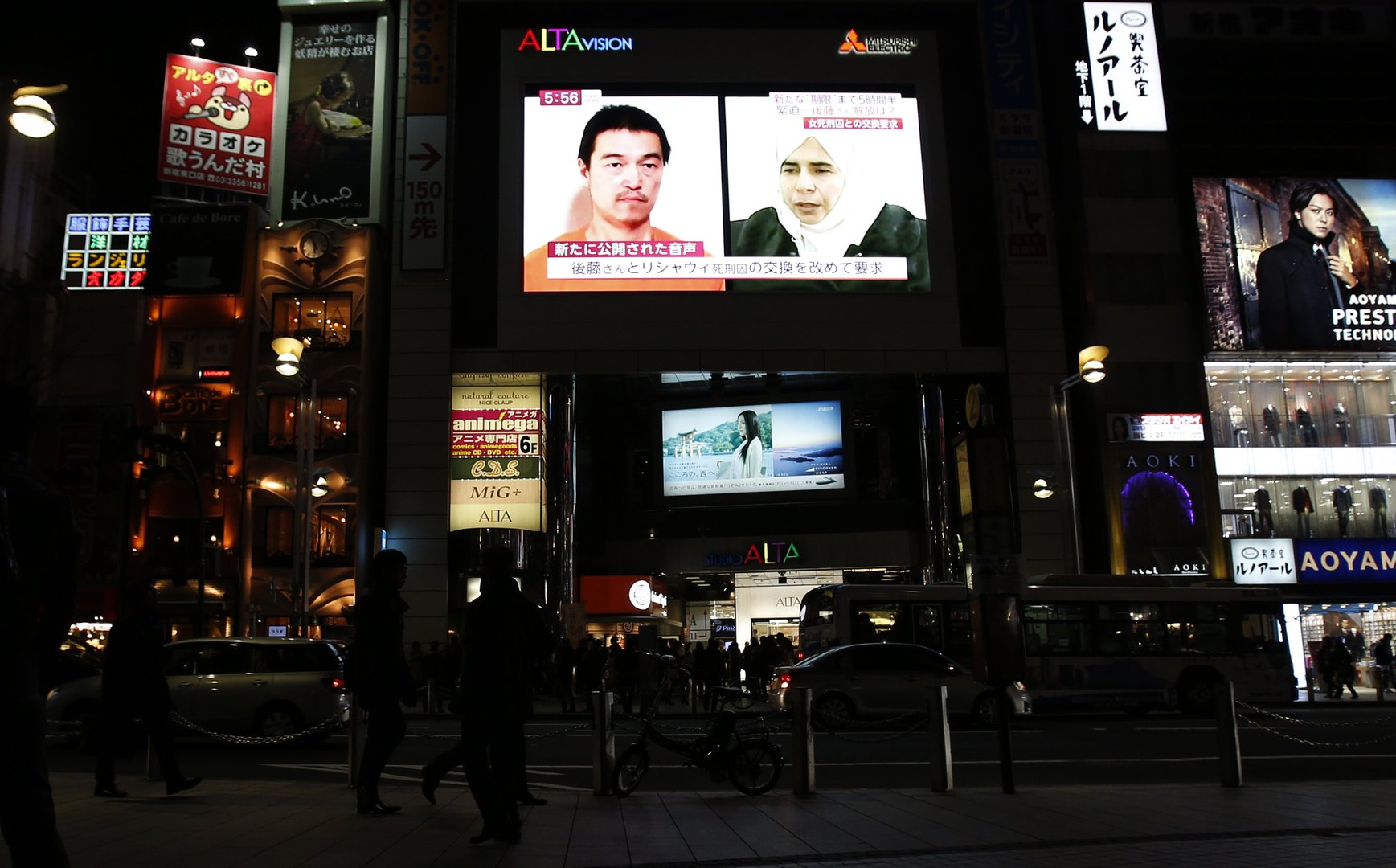 Een tv-scherm in Tokio toont een nieuwsprogramma waarin de foto's te zien zijn van de Japanse gegijzelde Goto en de Iraakse terreurverdachte tegen wie hij van IS moet worden uitgeruild.