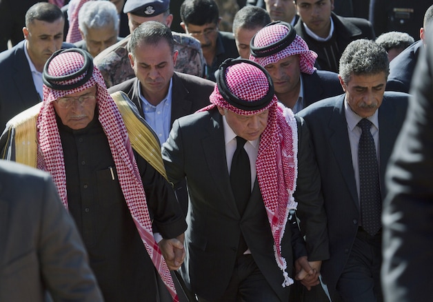 Koning Abdullah II, midden, naast de vader van de geëxecuteerde piloot Muaht al-Kaseasbeh (links), vandaag tijdens een herdenkingsplechtigheid.