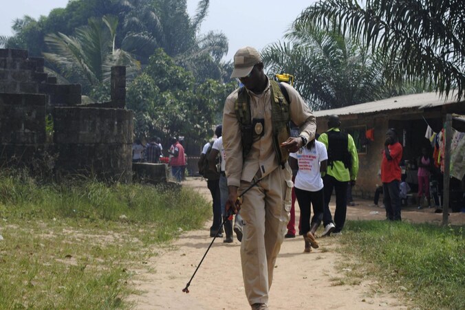 Een hulpverlener desinfecteert een weg in het door ebola getroffen Liberia.