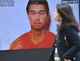 Een vrouw wandelt voorbij een tv-scherm in Tokio waarop de Japanese journalist Kenji Goto staat.