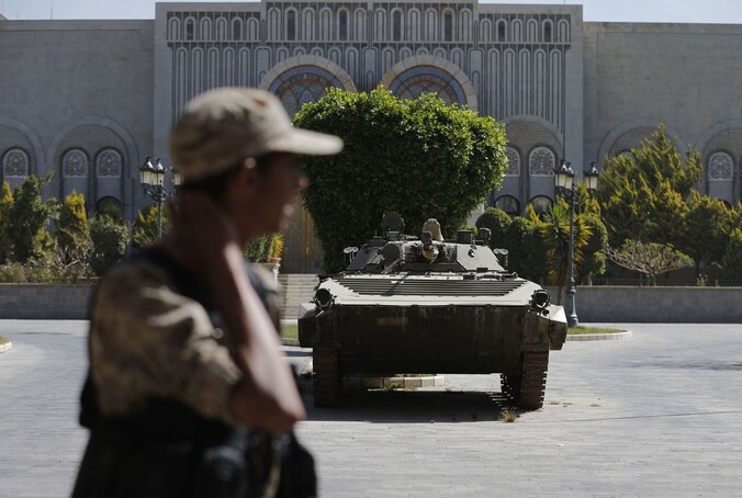 Een Hawthi houdt de wacht bij het Republikeins Paleis in hoofdstad Sanaa.