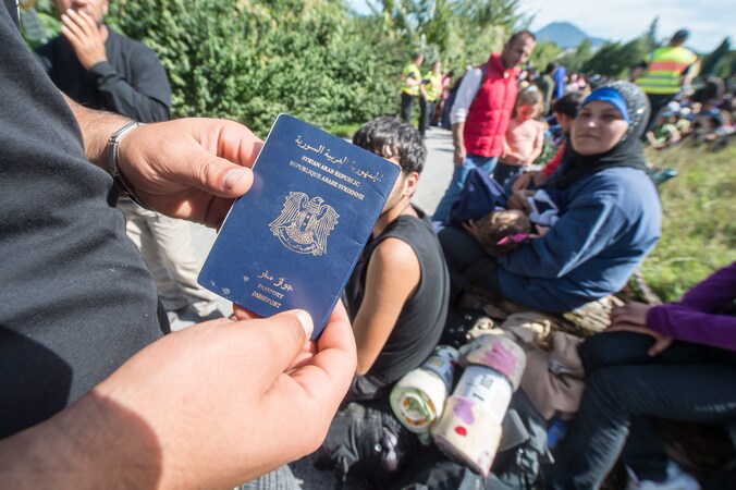 Een Syrische vluchteling toont zijn paspoort.