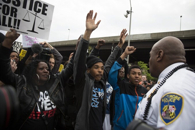 Een politieagent bij demonstranten die blij reageren op het nieuws over de vervolging