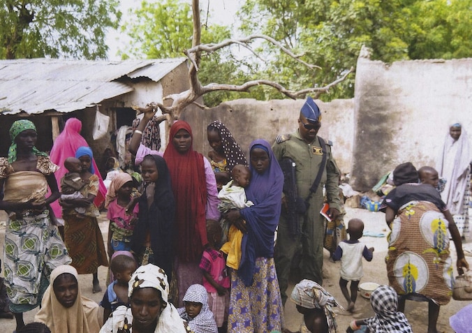 Een Nigeriaanse soldaat bij een groep vrouwen en meisjes die gered werden uit de handen van Boko Haram.