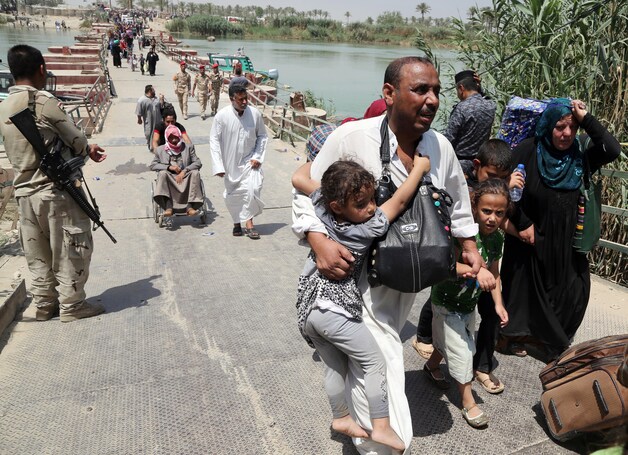 Vluhtende burgers steken een brug over bij Ramadi, op zo'n 65 kilometer van Bagdad.