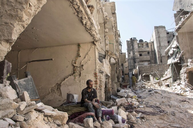 Een Syrische man aanschouwt het puin na de aanslag.